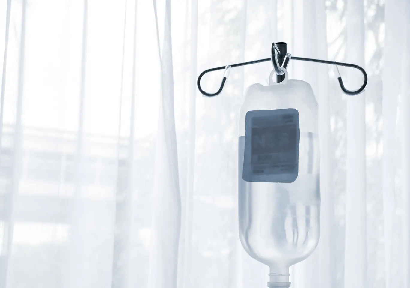 Kroplówki witaminowe Trzcianka: butelka płynu infuzyjnego zawieszona przy oknie