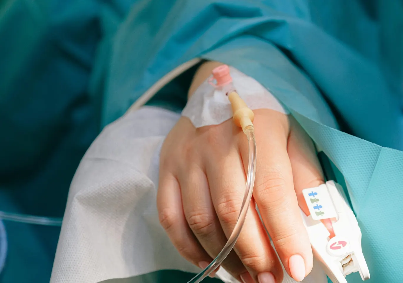 Detoks alkoholowy Wągrowiec: dłoń z wenflonem i pulsoksymetrem pod nadzorem